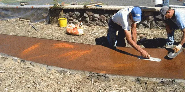 Operarios especialistas de Hormigón Impreso Juan SL aplicando moldes en un pavimento exterior en Sevilla