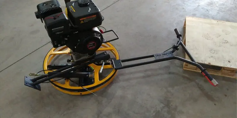 Máquina fratasadora alisando un pavimento de hormigón pulido industrial en una nave de Sevilla.